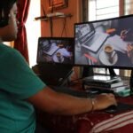 A person working from home in Kolkata with dual monitors, coffee, and headphones. Ideal for remote work concepts.