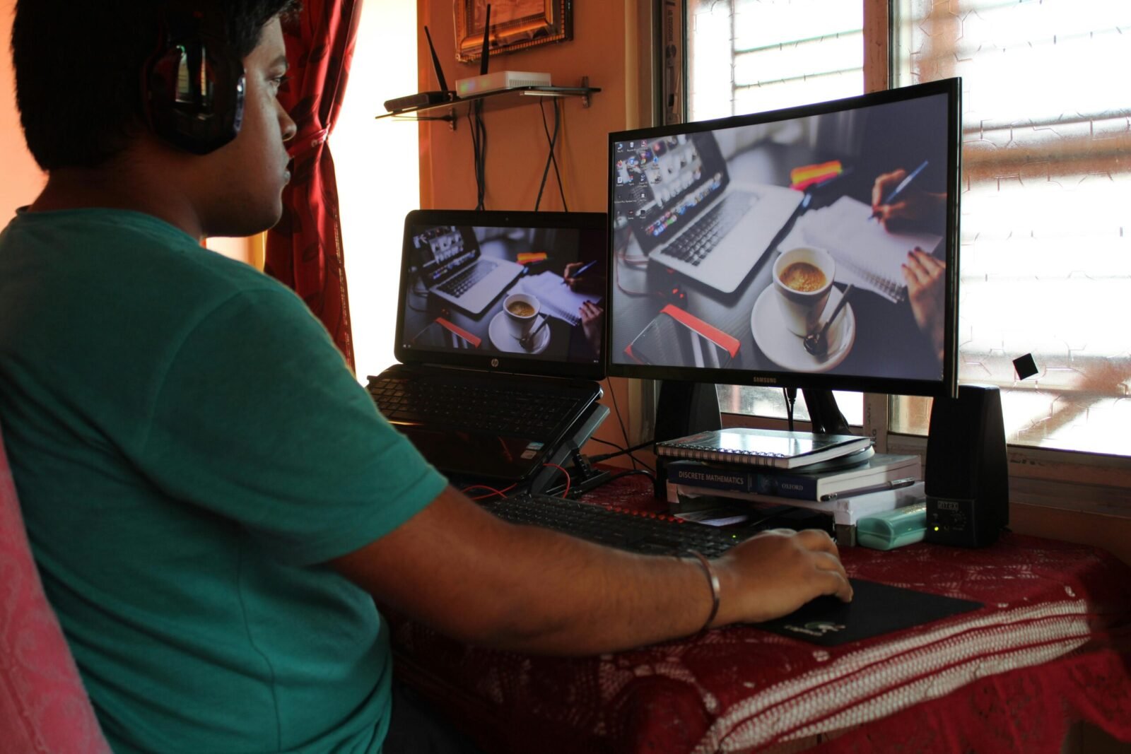 A person working from home in Kolkata with dual monitors, coffee, and headphones. Ideal for remote work concepts.